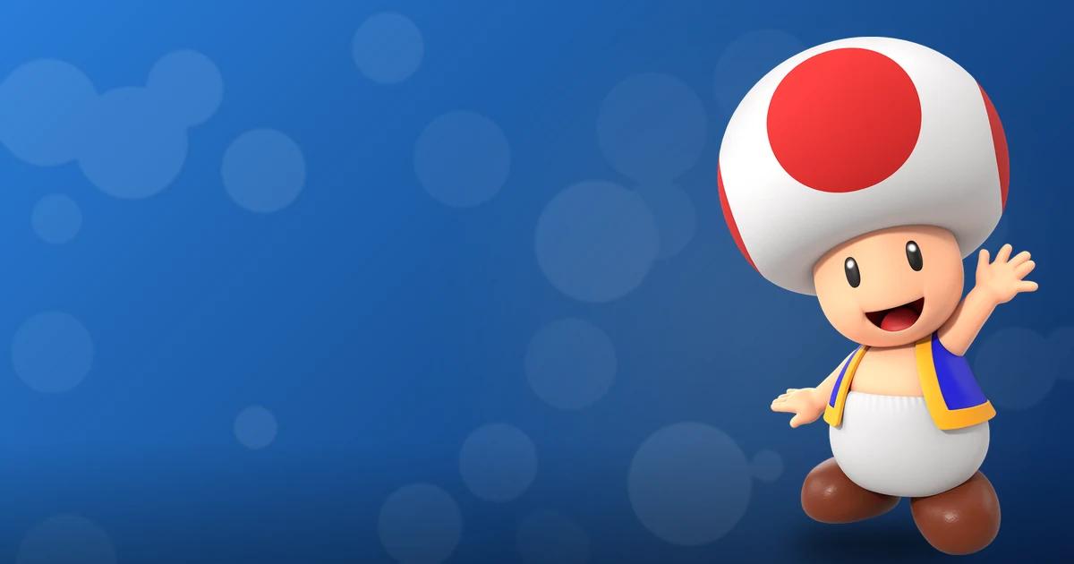 Toad, hongo asistente de Mario, saluda alegre con su seta blanca y roja icónica y chaleco azul Nintendo